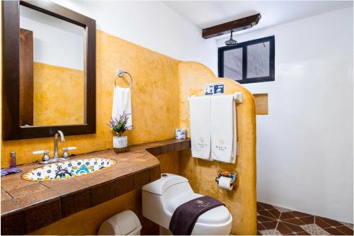 a bathroom with a sink and a toilet at Hotel Casa de las Flores in Playa del Carmen