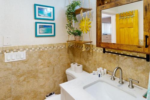 a bathroom with a sink and a toilet and a mirror at Saylor's Bay in Key Colony Beach