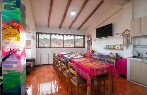 uma sala de jantar com uma mesa e algumas cadeiras em Pink Sheep Hostal em Cusco