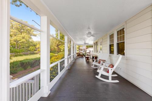 a porch of a white house with chairs and tables at The Salty Crab in Annapolis