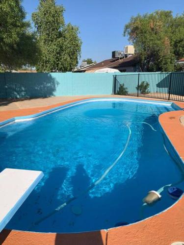 a large pool with blue water in a yard at Hideaway in the Heart of Phoenix with POOL in Phoenix