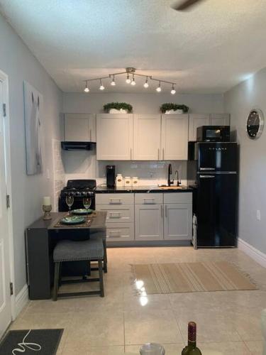 a kitchen with white cabinets and a black refrigerator at Hideaway in the Heart of Phoenix with POOL in Phoenix