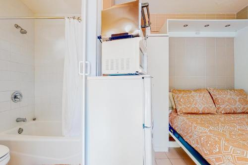 a small bathroom with a bed and a refrigerator at Sunshine Casita in Key West
