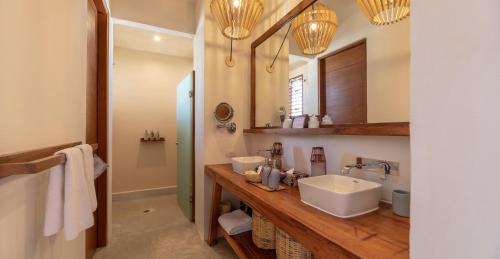 a bathroom with two sinks and a large mirror at La Zebra Tulum, a Small Luxury Hotel in Tulum