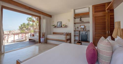 a bedroom with a bed and a view of the ocean at La Zebra Tulum, a Small Luxury Hotel in Tulum