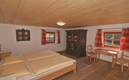 a bedroom with a bed and a table and a desk at Schmiedhäusl in Bruck an der Großglocknerstraße