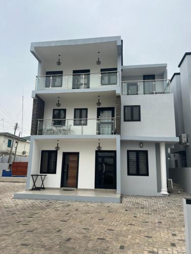 a white building with black windows and a balcony at The FJORD at Martsmith in Accra