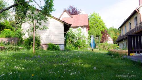 a yard with grass and flowers in front of a house at Entire House in Schwarzwald with mountain view, private Sauna, Gym, Garden and Terraces in Unterkirnach