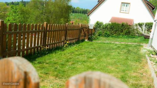 a wooden fence in a yard next to a house at Entire House in Schwarzwald with mountain view, private Sauna, Gym, Garden and Terraces in Unterkirnach