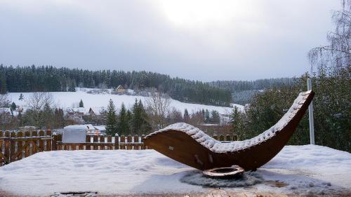 Une statue de guitare recouverte de neige dans la neige dans l'établissement Entire House in Schwarzwald with mountain view, private Sauna, Gym, Garden and Terraces, à Unterkirnach