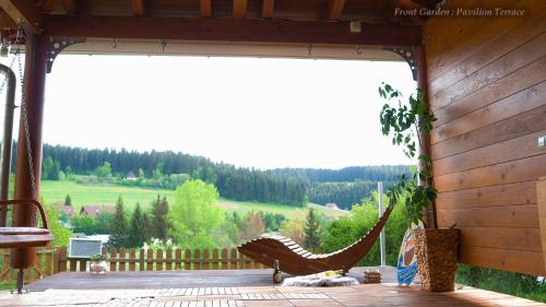 a hammock on a patio with a view of a hill at Entire House in Schwarzwald with mountain view, private Sauna, Gym, Garden and Terraces in Unterkirnach