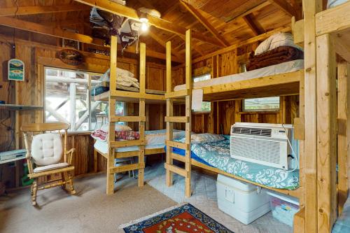 ein Schlafzimmer mit Etagenbetten in einer Holzhütte in der Unterkunft Cobbossee Hideaway in Winthrop