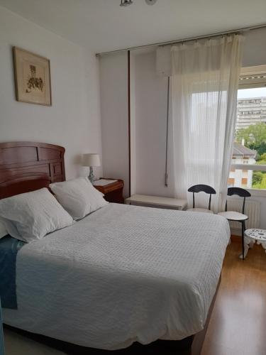 - une chambre avec un lit blanc et une fenêtre dans l'établissement Amplio piso muy luminoso y con vistas, à Laredo