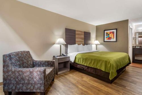 a hotel room with a bed and a chair at Quality Inn Conyers I-20 in Conyers