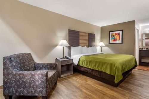 Quality Inn Conyers I-20 في كونيرز: غرفه فندقيه بسرير وكرسي