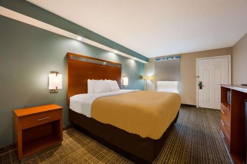 a hotel room with a large bed and a bathroom at Quality Inn Oxford Anniston I-20 in Oxford