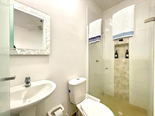 uma casa de banho com um WC, um lavatório e um espelho. em Aparta estudios nuevos Mubarak em Barranquilla