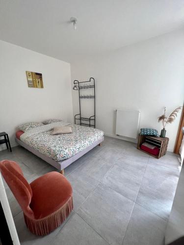 une chambre avec un lit et une chaise rouge dans l'établissement Duplex Saint Germain Bordeaux, à Bordeaux