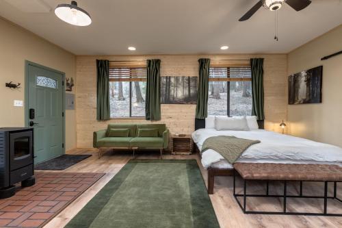 een slaapkamer met een groot bed en een groene bank bij Little House in the Big Woods in Forest Ranch