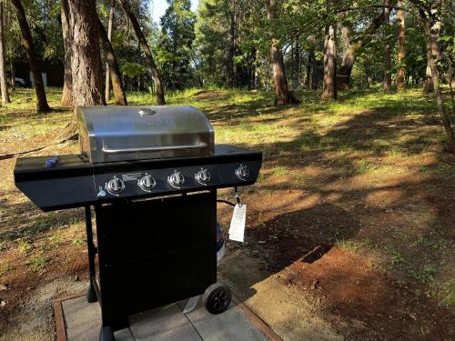 a black smoker with a grill in a park at Little House in the Big Woods in Forest Ranch