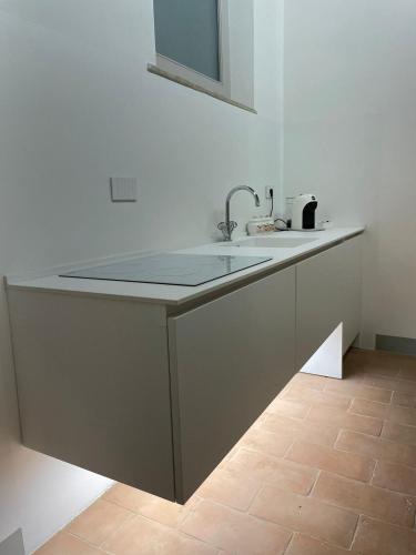 a white kitchen with a sink and a mirror at MontepulcianoLettings in Montepulciano
