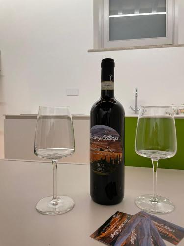 a bottle of wine and two glasses on a counter at MontepulcianoLettings in Montepulciano