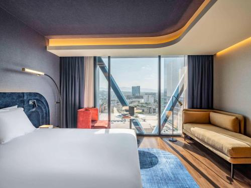 um quarto de hotel com uma cama e uma grande janela em Novotel Mexico City World Trade Center em Cidade do México