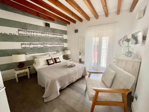 1 dormitorio con 1 cama y 1 silla en El 1 de Amador de los Rios, en Toledo