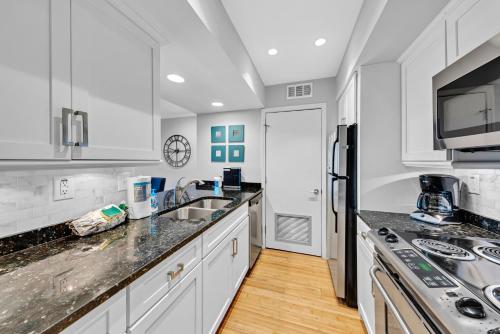 a kitchen with white cabinets and a counter top at 1303 Pelican Watch Villa in Seabrook Island