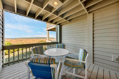 a table and chairs on a porch with a view at 1303 Pelican Watch Villa in Seabrook Island