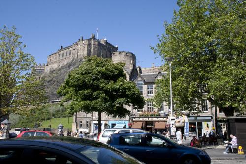 a busy street with cars parked in front of a castle at Apex City of Edinburgh Hotel in Edinburgh