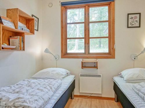 1 dormitorio con 2 camas y ventana en Three-Bedroom Holiday home in Rønne 4, en Rønne