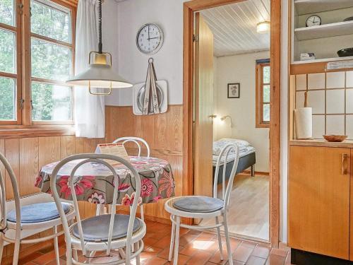 uma cozinha e sala de jantar com mesa e cadeiras em Three-Bedroom Holiday home in Rønne 4 em Rønne