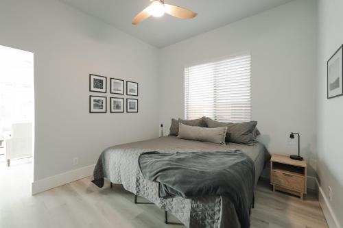 a white bedroom with a bed and a window at Modern Casita,Spa,Pool 10 Min to AZ Athletic Center in Mesa
