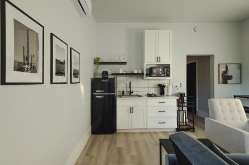 a kitchen with white cabinets and a black refrigerator at Modern Casita,Spa,Pool 10 Min to AZ Athletic Center in Mesa