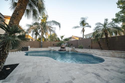 a swimming pool in a yard with palm trees at Modern Casita,Spa,Pool 10 Min to AZ Athletic Center in Mesa