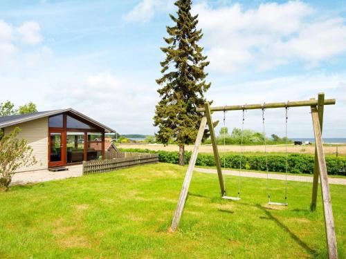Sønderbyにある5 person holiday home in Juelsmindeの木の横の庭のブランコ