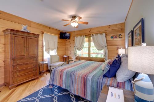 Schlafzimmer mit einem Bett und einem Deckenventilator in der Unterkunft Lakewood Lodge Escape with Fire Pit and Lake Access! in Hiwassee