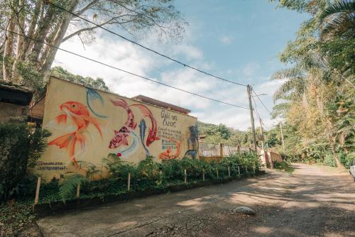 a building with a painting on the side of it at Chalé das Carpas in Penedo