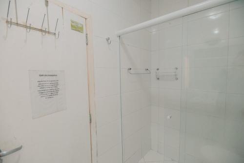 a bathroom with a shower with a glass door at Chalé das Carpas in Penedo