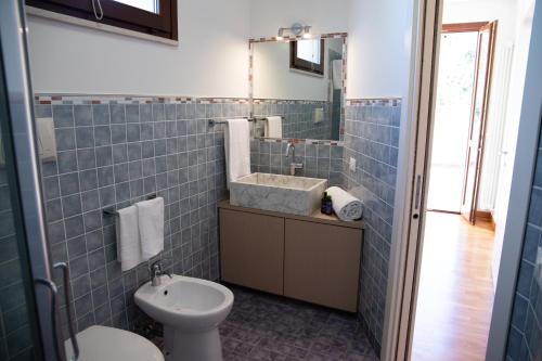 a blue tiled bathroom with a sink and a toilet at Sweet Home a Vallefoglia by Yohome in Montecchio
