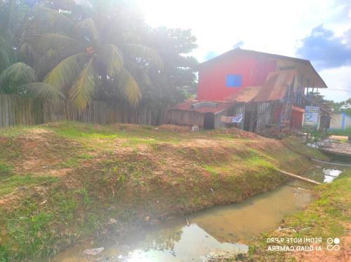 une maison avec une clôture à côté d'un petit étang dans l'établissement EL REENCUENTRO, à Pucallpa