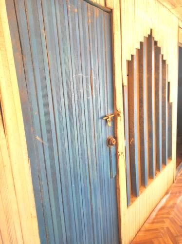 niebieskie drzwi do budynku z płotem w obiekcie EL REENCUENTRO w mieście Pucallpa