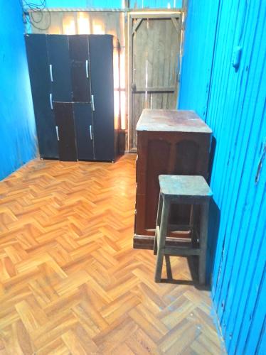 Pokój z drewnianą podłogą, stołkiem i szafkami w obiekcie EL REENCUENTRO w mieście Pucallpa