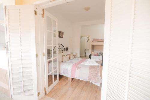 a bedroom with a bed in a room with white walls at Chalé das Carpas in Penedo