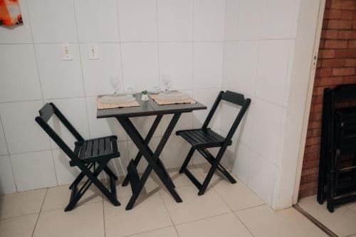 a small table and two chairs in a room at Chalé das Carpas in Penedo