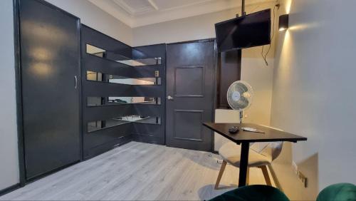a room with a table and a black door at Hotel Asturias in Viña del Mar