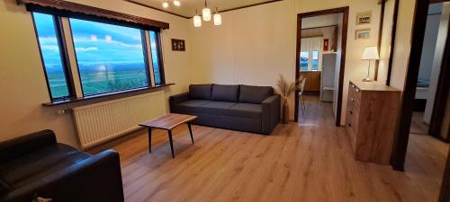 a living room with a couch and a large window at Guesthouse Klambrasel in Husavik