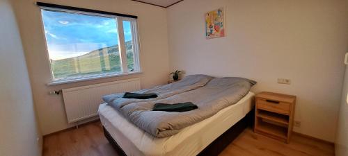 a small bedroom with a bed and a window at Guesthouse Klambrasel in Husavik