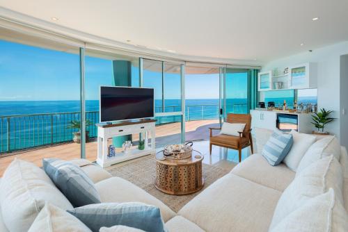 a living room with a white couch and a television at The Waterford on Main Beach in Gold Coast